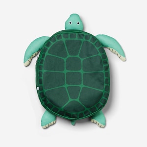 Könnte beinhalten: Ein grünes, schildkrötenförmiges Kissen. Der Panzer ist dunkelgrün mit einem helleren grünen Muster, und die Flossen und der Kopf sind hellgrün. Das Kissen ist so gestaltet, dass es wie eine Schildkröte aussieht, mit einem Reißverschluss auf dem Panzer.