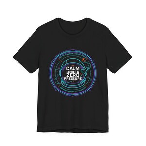 Peut inclure: T-shirt noir avec un motif circulaire représentant un casque spatial. Le design comprend le texte "CALM UNDER ZERO PRESSURE" en blanc, avec des accents bleus et violets. Les mots "DEEP SPACE SURVIVAL - SYSTEMS CHECKED" sont également inclus.