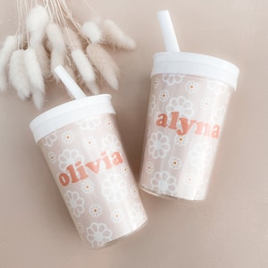 The left flower girl cup with the name Olivia and the right flower girl cup with the name Alyna