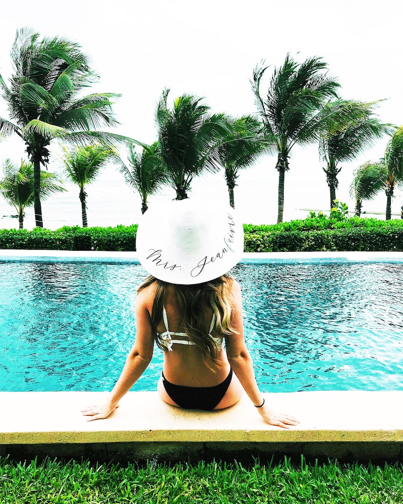 girl wearing white sun hat with black vinyl text