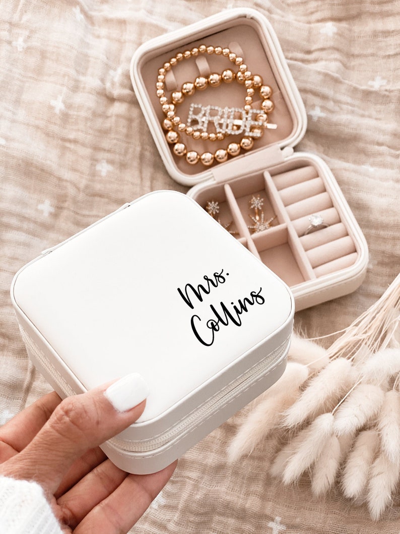 A small white faux leather jewelry box printed with Mrs. in black script text.