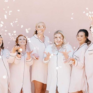 Six girls tossing confetti up in the air.