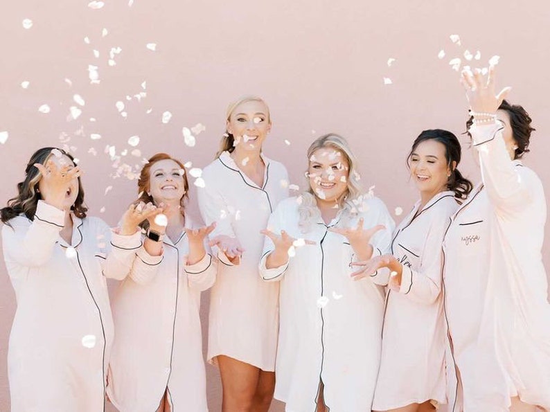 Six girls tossing confetti up in the air.