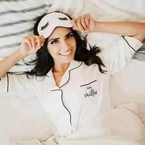 Women wearing a white sleep shirt with a white eyelash sleep mask. The shirt is personalized with the name mrs. miller