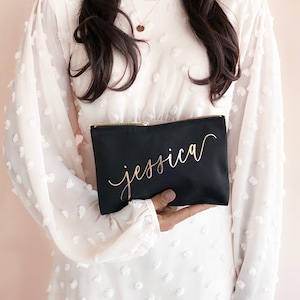 Women in white dress holding a black bag with rose gold name