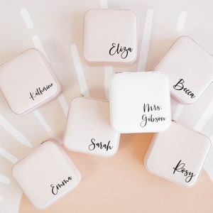 Blush pink and white jewelry boxes printed with custom names in black vinyl.