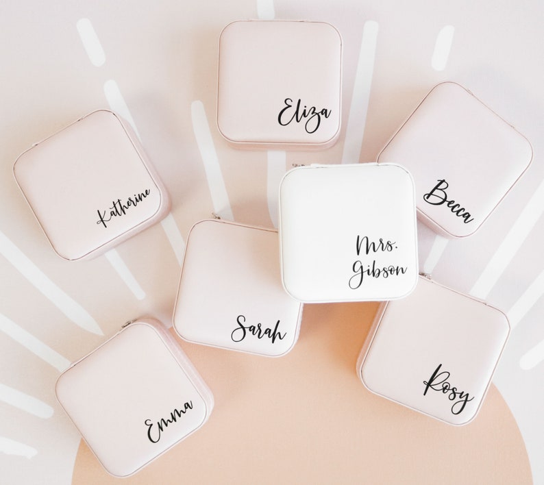 Blush pink and white jewelry boxes printed with custom names in black vinyl.