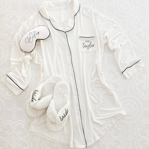 A white sleep shirt with slippers and a white eyelash designed sleep mask