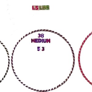 K&ouml;nnte beinhalten: Ein Diagramm, das drei verschiedene Gr&ouml;&szlig;en von gewichteten Hula-Hoops zeigt, jede mit einer anderen Farbe und einem anderen Durchmesser. Die Gr&ouml;&szlig;en sind 36 Zoll, 38 Zoll und 40 Zoll. Die Gewichte betragen 1,5 Pfund. Das Diagramm enth&auml;lt auch die empfohlene H&ouml;he f&uuml;r jede Gr&ouml;&szlig;e des Hula-Hoops.