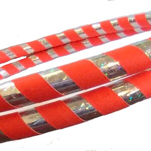 K&ouml;nnte beinhalten: Zwei rot-silber gestreifte Hula-Hoops. Die Reifen liegen &uuml;bereinander.