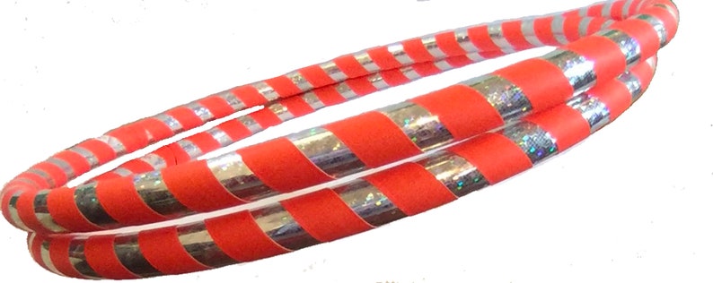 K&ouml;nnte beinhalten: Zwei rot-silber gestreifte Hula-Hoops. Die Reifen liegen &uuml;bereinander.