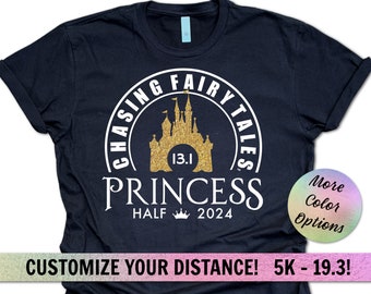 Może przedstawiać: Czarny T-shirt z projektem zamku w złotym brokacie i tekstem "Chasing Fairy Tales 13.1 Princess Half 2024". Tekst "Więcej opcji kolorów" znajduje się w kółku z tęczowym gradientem.