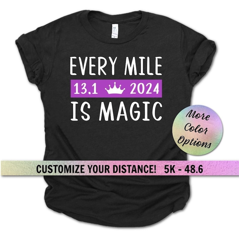 May include: Black t-shirt with white text that reads "Every Mile 13.1 2024 Is Magic". The text is in a purple banner with a crown icon. The text "Customize Your Distance! 5K - 48.6" is at the bottom of the shirt.