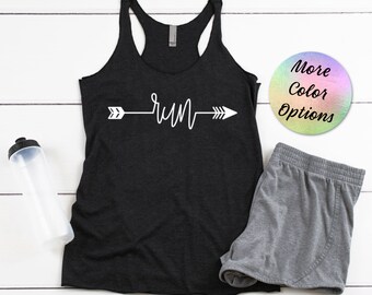 Puede incluir: Camiseta sin mangas negra con la palabra "run" en blanco, diseñada como una flecha. Pantalones cortos deportivos grises y una botella de agua también están en la imagen. Un gráfico circular con "More Color Options" está en la esquina superior derecha.