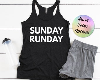Könnte beinhalten: Ein schwarzes Tanktop mit weißem Text, der "SUNDAY RUNDAY" lautet. Das Tanktop wird mit grauen Sport-Shorts kombiniert. Eine Wasserflasche und ein runder Aufkleber mit dem Text "More Color Options" sind ebenfalls auf dem Bild zu sehen.