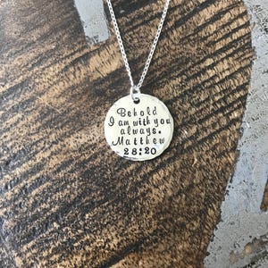 May include: Silver necklace with a round pendant that says "Behold I am with you always. Matthew 28:20"
