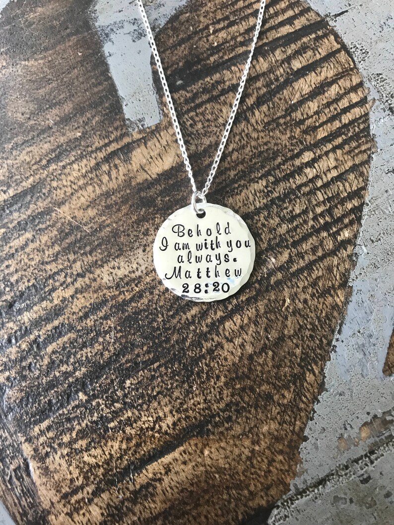 May include: Silver necklace with a round pendant that says "Behold I am with you always. Matthew 28:20"