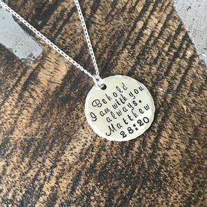 May include: A silver necklace with a round pendant that says "Behold I am with you always. Matthew 28:20"