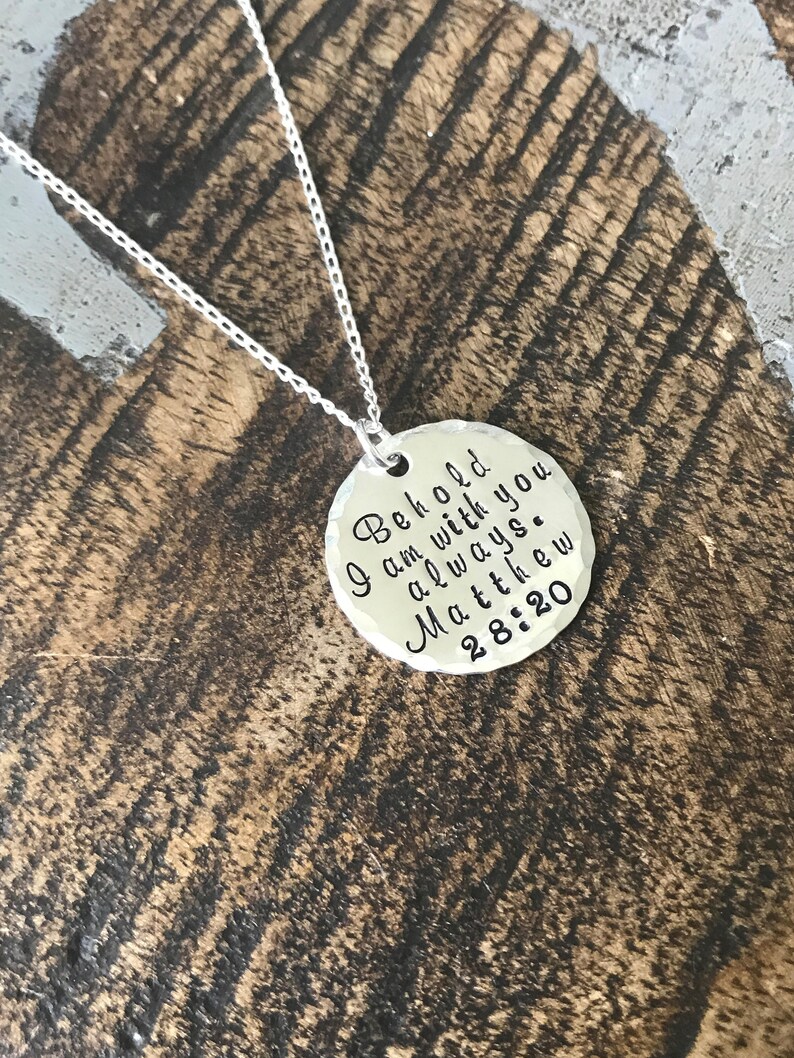 May include: A silver necklace with a round pendant that says "Behold I am with you always. Matthew 28:20"