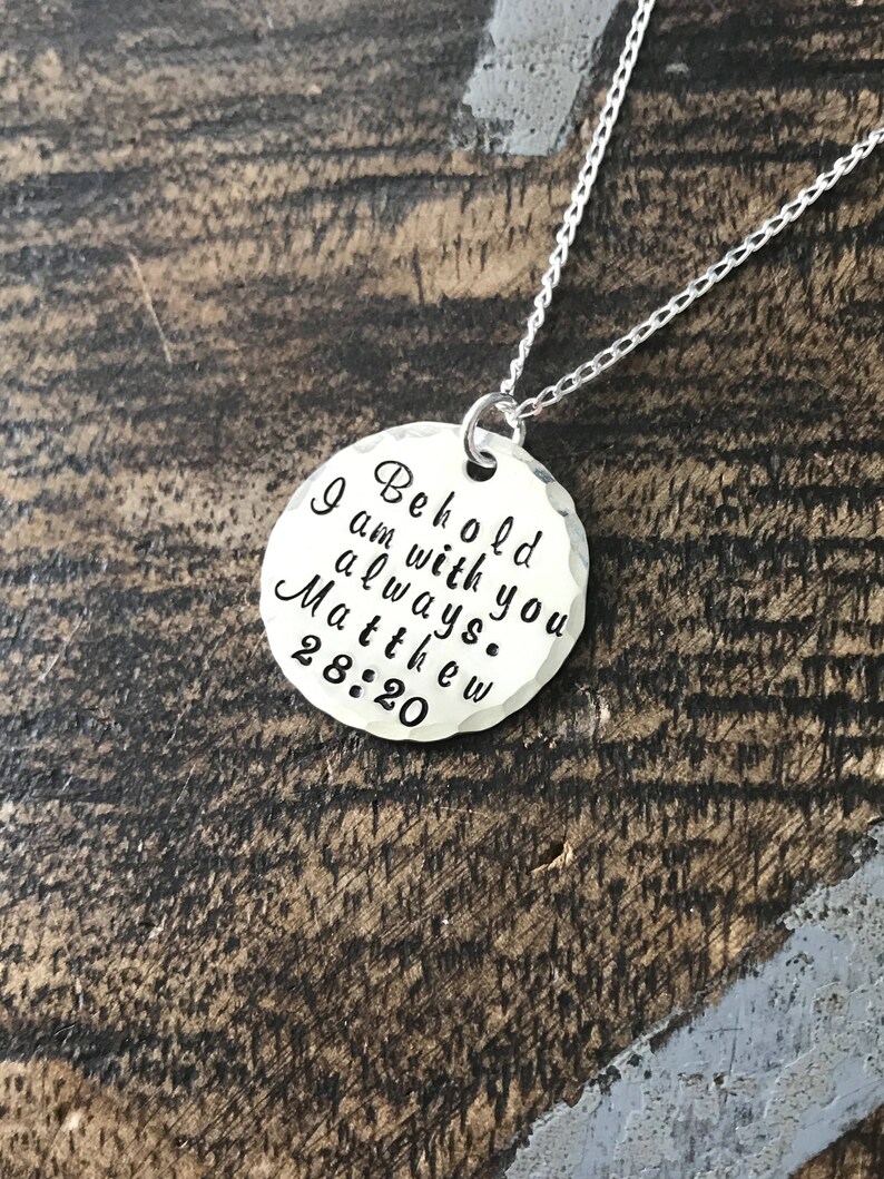 May include: Silver necklace with a round pendant that reads "Behold I am with you always. Matthew 28:20".