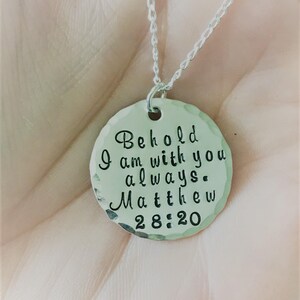 May include: Silver necklace with a round pendant that says "Behold I am with you always. Matthew 28:20".