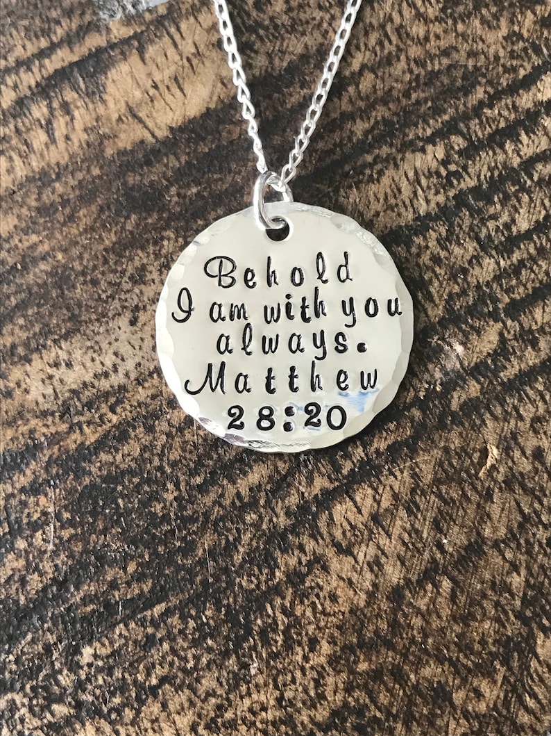 May include: Silver necklace with a round pendant that reads "Behold I am with you always. Matthew 28:20".