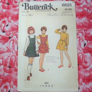 May include: A vintage sewing pattern for girls' dresses. The pattern is for sizes 7 to 14 and includes a transfer pattern for smocking. The pattern is from Butterick, the Fashion One, and is number 6825. The pattern is for a dress with a smocked bodice and a skirt. The pattern is for a dress with a solid color bodice and a printed skirt. The pattern is for a dress with a solid color bodice and a solid color skirt.
