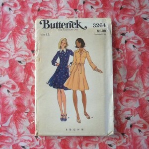 May include: A vintage sewing pattern for a dress, Butterick 3264, size 12. The pattern shows two women wearing different versions of the dress, one with a floral print and the other in a solid color.