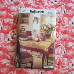 May include: A sewing pattern envelope for a tablecloth featuring a floral design. The pattern is by Butterick and the number is 6620. The envelope shows a table setting with a tablecloth, chairs, and a floral centerpiece.