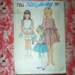 May include: Simplicity sewing pattern number 7153 for a girl's dress. The pattern includes three different dress styles: a white dress with puffed sleeves, a striped dress with a sash, and a floral print dress. The pattern is for size 8 with a 26 inch bust.