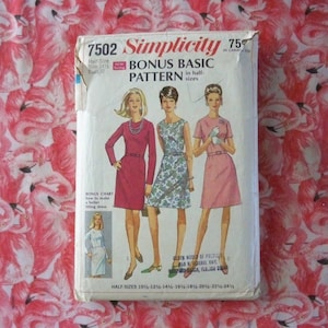 May include: Simplicity sewing pattern number 7502, a bonus basic pattern in half sizes. The pattern is for a dress with three different styles. The pattern cover features three women wearing the dress in different colors and styles. The text on the cover reads "Simplicity 7502 Bonus Basic Pattern in half sizes".
