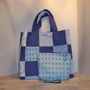 以下が含まれることがあります： 青と白のパッチワークのトートバッグと、それに合わせた青と白のドット柄のジッパー付きポーチ。トートバッグには青いタッセルが付いている。