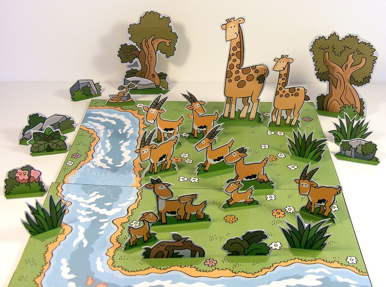 May include: A paper craft set featuring a river, trees, and animals. The set includes a giraffe, a smaller giraffe, and several brown and white gazelles. The animals are all standing on a green grassy field with white flowers.