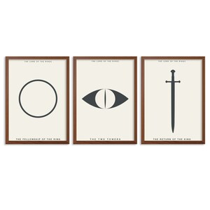 May include: Three framed prints with minimalist designs representing the three Lord of the Rings books. The first print features a circle, the second print features an eye, and the third print features a sword. The text below each print reads "The Fellowship of the Ring", "The Two Towers", and "The Return of the King".