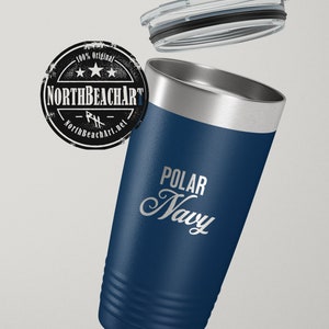 May include: A stainless steel tumbler with a navy blue exterior and a silver lid. The tumbler has a white inscription that reads "POLAR NAVY".