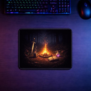 Könnte beinhalten: Rechteckiges Mousepad mit einer Fantasy-Szene. Es zeigt ein Lagerfeuer, ein Schwert, eine Tasse, eine Flasche mit Trank und ein offenes Buch. Das Kunstwerk zeigt eine Waldszene mit warmen Farben.