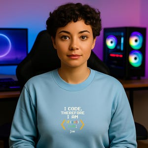 Peut inclure: Un sweat-shirt bleu clair avec le texte "I CODE, THEREFORE I AM" et un extrait de code. Le code se lit "if (x-5) code; )=". Le sweat-shirt est port&eacute; par une personne aux cheveux courts et fonc&eacute;s.