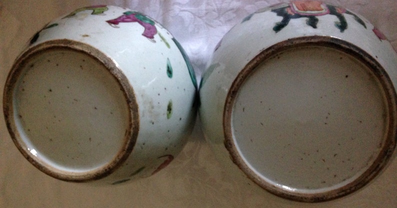 May include: Two white porcelain bowls with a brown rim. The bowls are decorated with colourful painted figures and flowers.