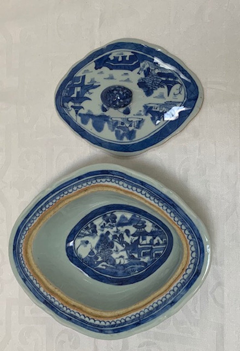 May include: A blue and white porcelain oval serving dish with a lid. The dish has a blue and white floral design with a border of blue and white dots. The lid has a similar design with a knob in the center.