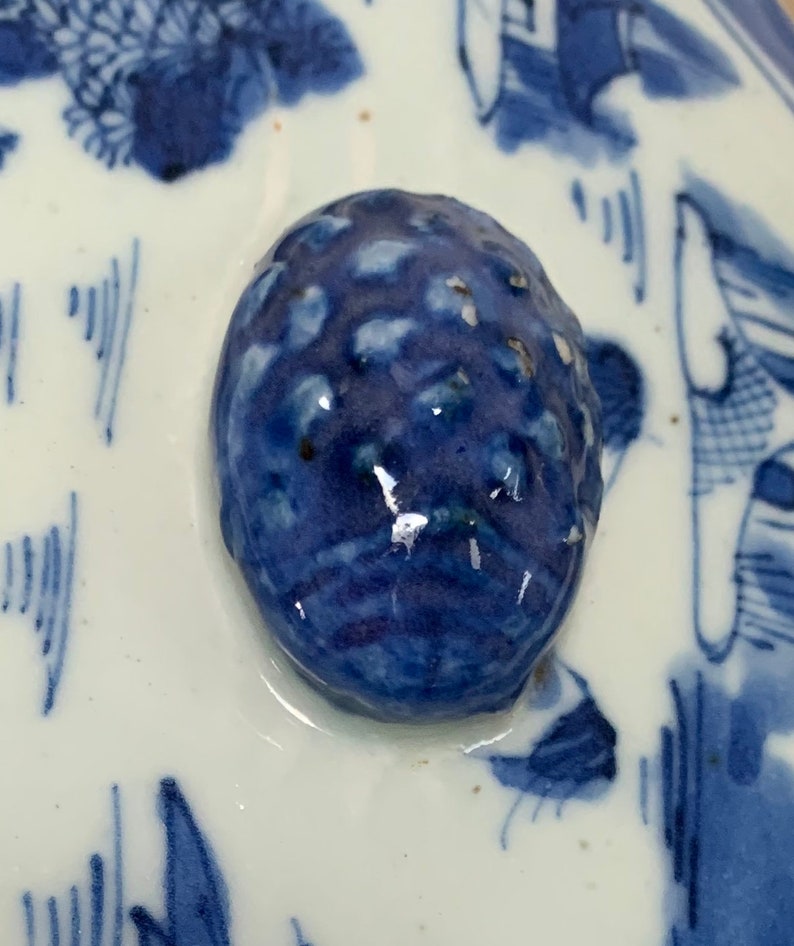 May include: Close-up of a blue and white ceramic knob with a textured surface. The knob is round and has a glossy finish.