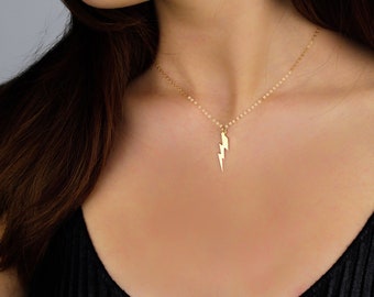 May include: A gold chain necklace with a lightning bolt pendant.