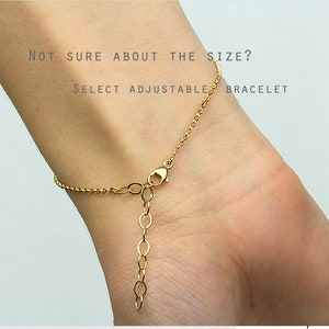 May include: A gold-toned chain bracelet featuring a lobster claw clasp and an adjustable extender chain. The text "NOT SURE ABOUT THE SIZE? SELECT ADJUSTABLE BRACELET" is printed in dark grey lettering across the upper portion of the image.