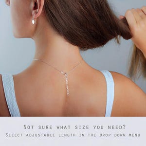 May include: A silver chain necklace featuring an adjustable extender link section at the back. The necklace is worn around the neck, with the silver chain and extender clearly visible. Text below reads: NOT SURE WHAT SIZE YOU NEED? SELECT ADJUSTABLE LENGTH IN THE DROP DOWN MENU.