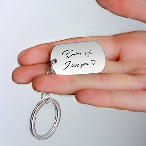 May include: Silver keychain with a silver tag that reads "Drive safe I love you" with a heart symbol.