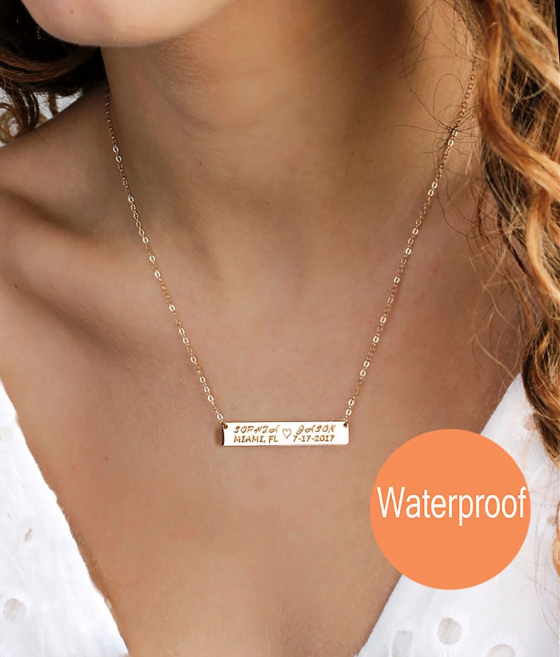 May include: Gold bar necklace with a personalized inscription that reads "Sophia ♡ Jackson Miami, FL 7-17-2017". The necklace is waterproof.