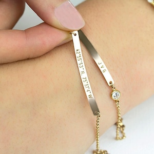 May include: Gold bracelet with two charms. One charm has the coordinates 42.55.53 - N. 75.51.4 - W engraved on it. The other charm has the initials JVG engraved on it. The bracelet also has a small clear rhinestone.