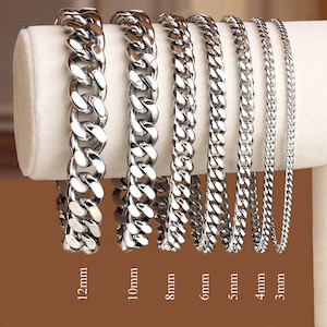 May include: Seven silver curb chain bracelets of varying widths, from 3mm to 12mm, displayed on a white surface. The bracelets are arranged from smallest to largest, with the width of each bracelet labeled below it.