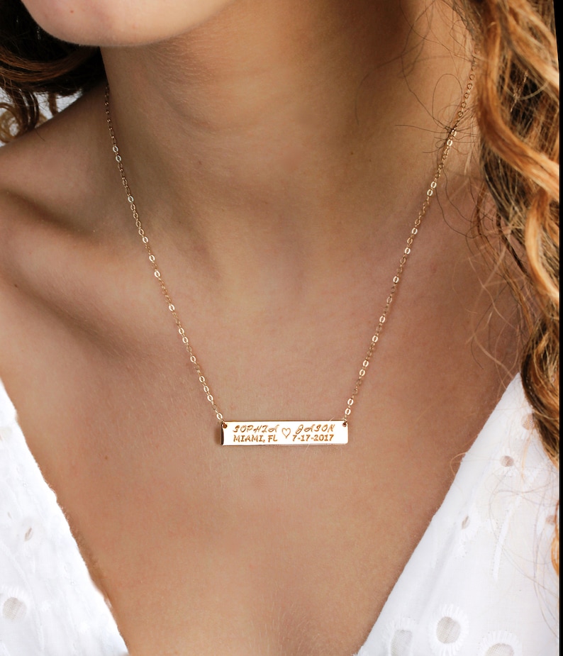 May include: Gold chain necklace with a personalized bar pendant engraved with "Sophia Jason Miami, FL 7-17-2017".