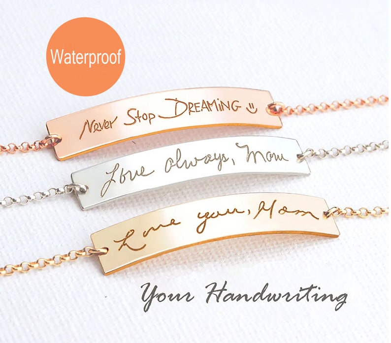 May include: Three metal bar bracelets with delicate chains, featuring custom engraved handwriting. The top bar is rose gold with "Never Stop DREAMING" and a smiley face, the middle is silver with "Love always, Mom", and the bottom is gold with "Love you, Mom".