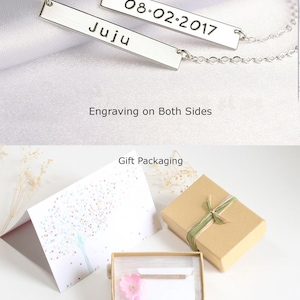 May include: A silver necklace with two bar pendants. The top pendant is engraved with the date "08.02.2017" and the bottom pendant is engraved with the name "Juju". The necklace is displayed on a white surface with the text "Engraving on Both Sides" below it. The image also shows a gift box and a card with a tree design.